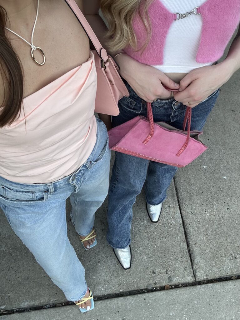 All pink spring outfit featuring a pink top, blue jeans, gold accessories, and white sneakers styled for a soft girl aesthetic.